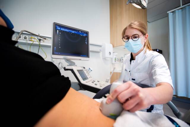 zorgmedewerker maakt een echo van de buik van patiënt