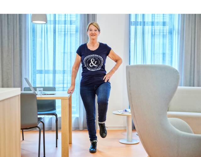 Vrouw doet staande oefening met 1 been omhoog
