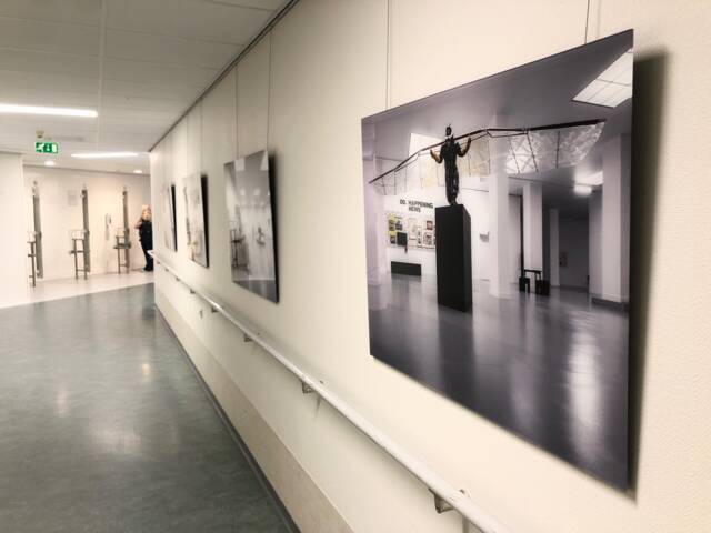 Foto van een man met vleugels aan een muur in de gang