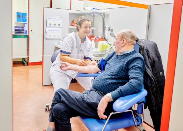 Verpleegkundige neemt bloed af bij patiënt