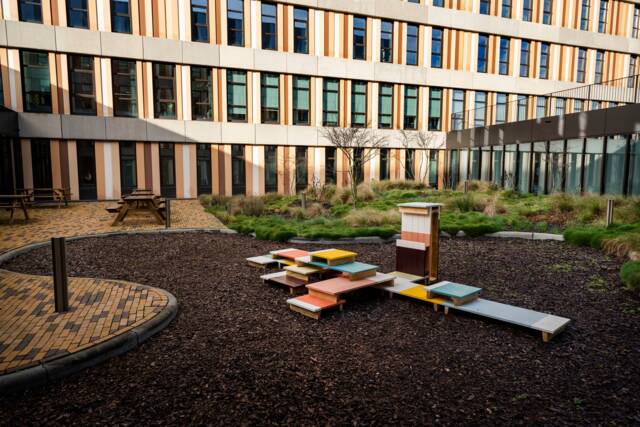 Compositie van gekleurde pallet-achtige objecten met hoogteverschil in een binnentuin
